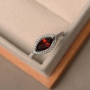 Shop Garnet Engagement Rings! Marquise cut red garnet ring, engagement ring, sterling silver, January birthstone gemstone, halo ring | Natural genuine Garnet rings, simple unique alternative gemstone engagement rings. #rings #jewelry #bridal #wedding #jewelryaccessories #engagementrings #weddingideas #affiliate #ad