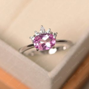 Shop Pink Sapphire Rings! Pink sapphire ring, oval cut, sterling silver, half halo ring, engagement ring for women | Natural genuine Pink Sapphire rings, simple unique alternative gemstone engagement rings. #rings #jewelry #bridal #wedding #jewelryaccessories #engagementrings #weddingideas #affiliate #ad