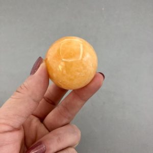 Shop Orange Calcite Shapes! Orange Calcite Sphere with Stand | Natural genuine stones & crystals in various shapes & sizes. Buy raw cut, tumbled, or polished gemstones for making jewelry or crystal healing energy vibration raising reiki stones. #crystals #gemstones #crystalhealing #crystalsandgemstones #energyhealing #affiliate #ad