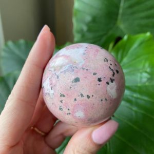 Shop Rhodonite Shapes! Rhodonite sphere, orb | Natural genuine stones & crystals in various shapes & sizes. Buy raw cut, tumbled, or polished gemstones for making jewelry or crystal healing energy vibration raising reiki stones. #crystals #gemstones #crystalhealing #crystalsandgemstones #energyhealing #affiliate #ad