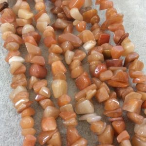 Shop Aventurine Chip & Nugget Beads! Natural Orange Aventurine Chunky Nugget Shaped Beads with 1mm Holes – Sold by 16" Strands (Approx. 75-80 Beads) – Measuring 10-15mm Wide | Natural genuine chip Aventurine beads for beading and jewelry making.  #jewelry #beads #beadedjewelry #diyjewelry #jewelrymaking #beadstore #beading #affiliate #ad
