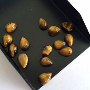 Shop Tiger Eye Cabochons! 25 Pieces 10x7mm Each Smooth Tigers Eye Pear Shaped Brown Color Loose Cabochons SKU-TI3 | Natural genuine stones & crystals in various shapes & sizes. Buy raw cut, tumbled, or polished gemstones for making jewelry or crystal healing energy vibration raising reiki stones. #crystals #gemstones #crystalhealing #crystalsandgemstones #energyhealing #affiliate #ad