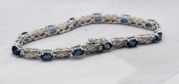 Bracelet, London Blue Topaz, Genuine Gemstones, Twelve 6x4 Mm Faceted Oval Gemstones, Set In 925 Sterling Silver With Double Clip Box Clasp