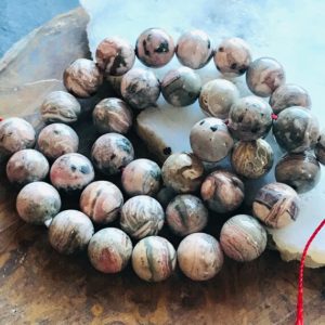Shop Rhodochrosite Round Beads! Banded Rhodochrosite beads smooth rounds 10mm polished full designer strand | Natural genuine round Rhodochrosite beads for beading and jewelry making.  #jewelry #beads #beadedjewelry #diyjewelry #jewelrymaking #beadstore #beading #affiliate #ad