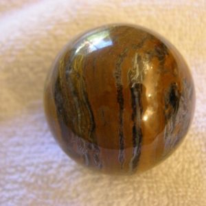 Shop Tiger Iron Stones & Crystals! Tiger iron sphere hand carved polished 2+ inch + acrylic ring stand | Natural genuine stones & crystals in various shapes & sizes. Buy raw cut, tumbled, or polished gemstones for making jewelry or crystal healing energy vibration raising reiki stones. #crystals #gemstones #crystalhealing #crystalsandgemstones #energyhealing #affiliate #ad
