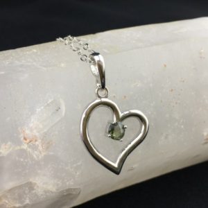 Heart Signature! A 5mm Faceted Genuine Moldavite Held Within a Sterling Silver Rhodium Plated Heart | Natural genuine stones & crystals in various shapes & sizes. Buy raw cut, tumbled, or polished gemstones for making jewelry or crystal healing energy vibration raising reiki stones. #crystals #gemstones #crystalhealing #crystalsandgemstones #energyhealing #affiliate #ad
