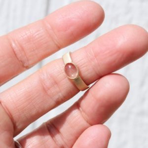 Shop Sunstone Rings! Modern Pale Clear Oregon Sunstone Ring 14K Yellow Gold Brushed Finish Bezel Set Wedding Band Nude Peach Rose Pink Oval Cabochon – Sonnensee | Natural genuine Sunstone rings, simple unique alternative gemstone engagement rings. #rings #jewelry #bridal #wedding #jewelryaccessories #engagementrings #weddingideas #affiliate #ad