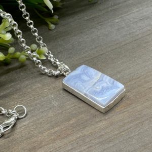 Shop Blue Lace Agate Pendants! Genuine Blue Lace Agate Rectangle Cabochon Focal Stone Pendant | Set in .925 sterling silver with 19 inch silver plated rolo chain | Natural genuine Blue Lace Agate pendants. Buy crystal jewelry, handmade handcrafted artisan jewelry for women.  Unique handmade gift ideas. #jewelry #beadedpendants #beadedjewelry #gift #shopping #handmadejewelry #fashion #style #product #pendants #affiliate #ad