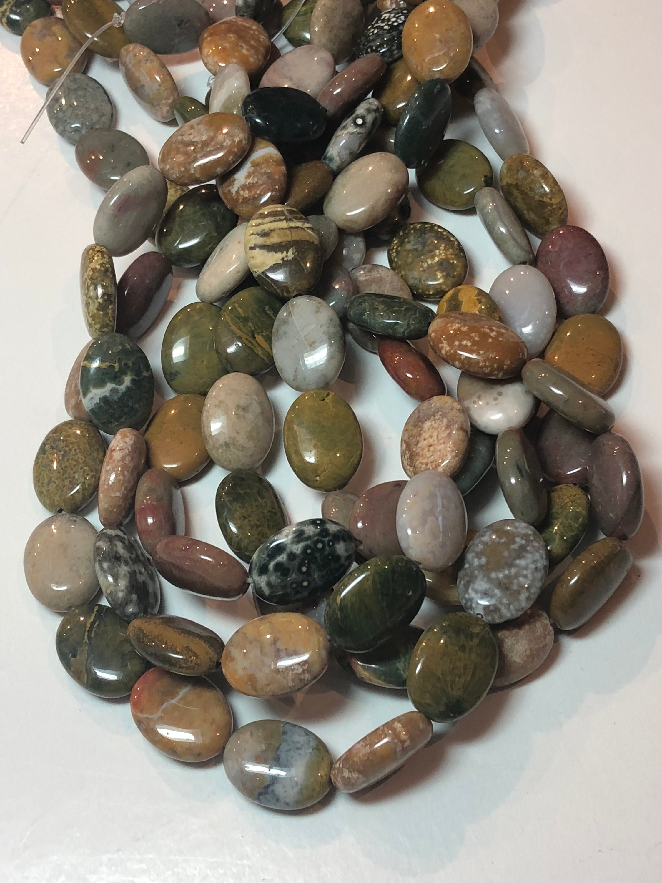Ocean Jasper Gemstone Beads. 12x16mm Flat Oval Beads On 15 Inch Strand. Full Strand Of A Grade Beads, Roughly 24 Beads Per Strand. Ocean Jasper Gemstone Beads. 12x16mm Flat Oval Beads On 15 Inch Strand. Full Strand Of A Grade Beads, Roughly 24 Beads Per Strand.