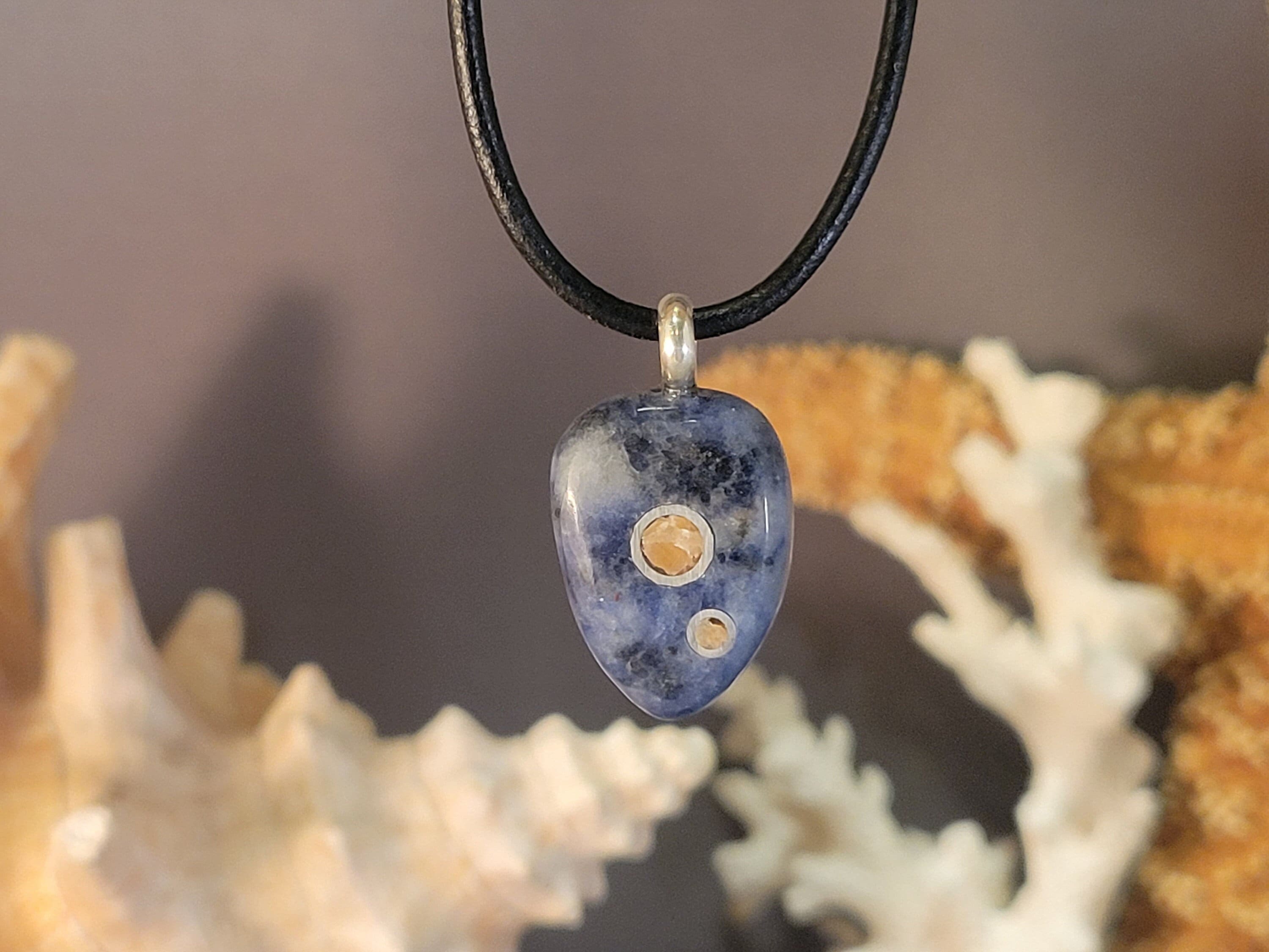 Sodalite Stone Pendant Inlaid With Sterling Silver Rings And Orange Calcite Gemstone With A Sterling Silver Bail. Sodalite Stone Pendant Inlaid With Sterling Silver Rings And Orange Calcite Gemstone With A Sterling Silver Bail.