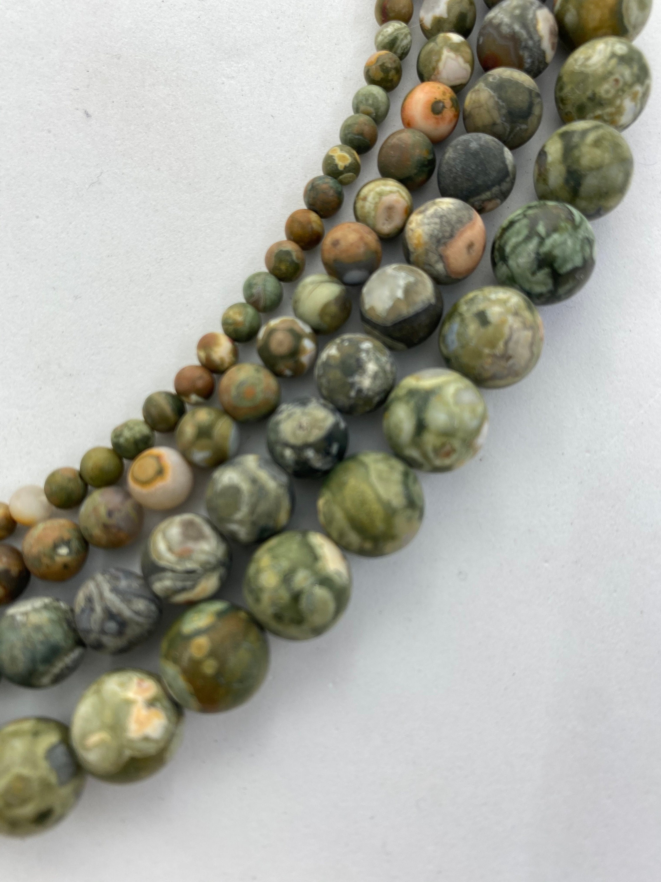 Matte Green Rhyolite Gemstone Beads, Available In 4-10mm. 15” Strands Of Round Beads. Sometimes Called Rain Forest Stone.